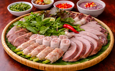 Assorted Vietnamese meats and herbs on a platter, part of Hanoi's hidden local dishes tour.