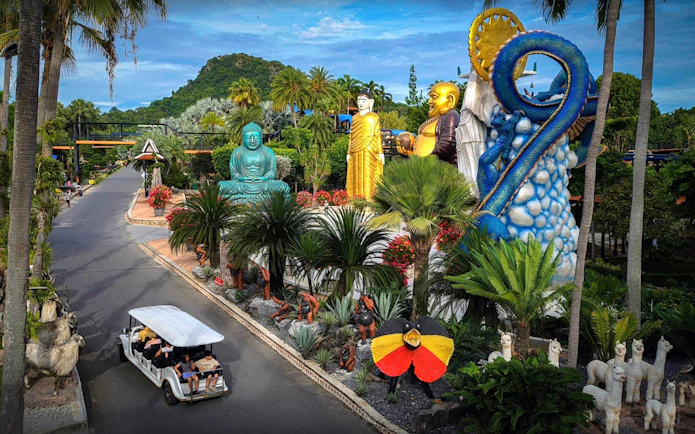 Nong Nooch Tropical Garden statues and sculptures with a tour cart on the path.