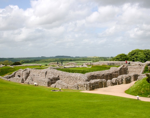Old Sarum ruins with green landscape and cloudy sky in Salisbury, England.