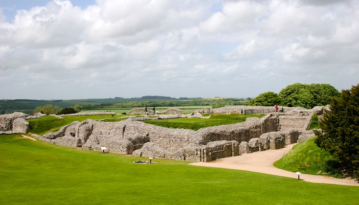 Old Sarum ruins with green landscape and cloudy sky in Salisbury, England.