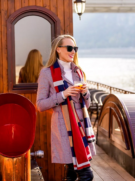 Woman enjoying a drink on a historic cruise in Budapest.