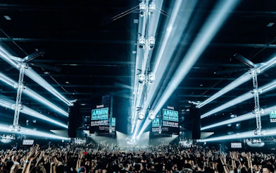 Armin Van Buuren performing live with vibrant lights and crowd in Ibiza.