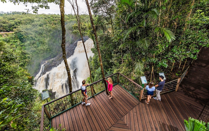 Visitors at Barron Falls lookout near Skyrail station, surrounded by lush rainforest.