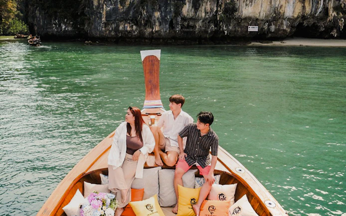 Tourists on a luxury longtail boat in Krabi, Thailand, near Koh Hong cliffs.
