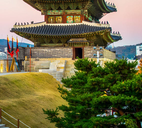 Traditional Korean pavilion at Korean Folk Village with surrounding greenery.