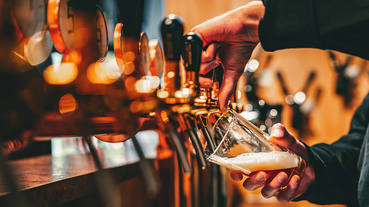Hand pouring beer from tap at The Lamb & Flag in London’s theatre district.