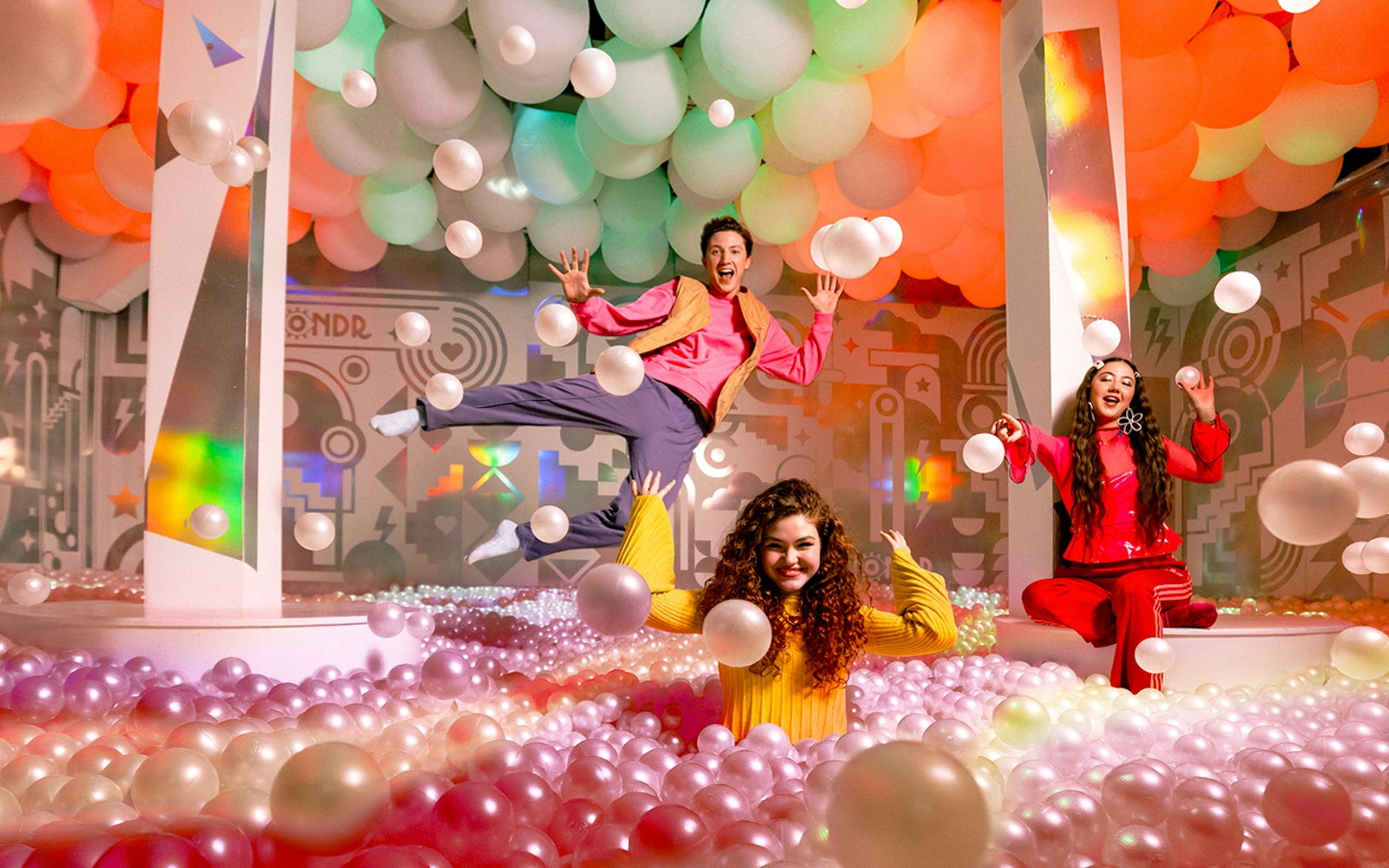 Visitors enjoying colorful ball pit at WONDR Experience.