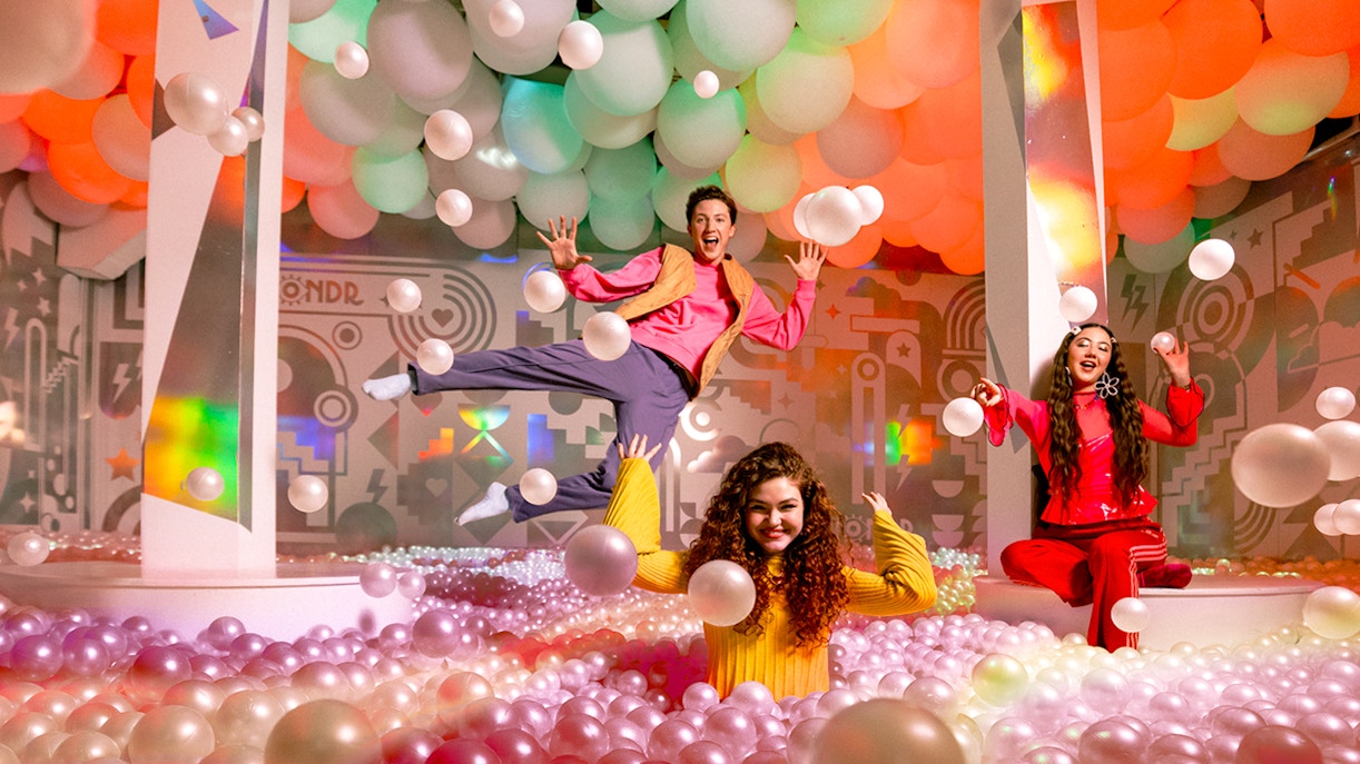 Visitors enjoying interactive art installations at WONDR Experience, Amsterdam.