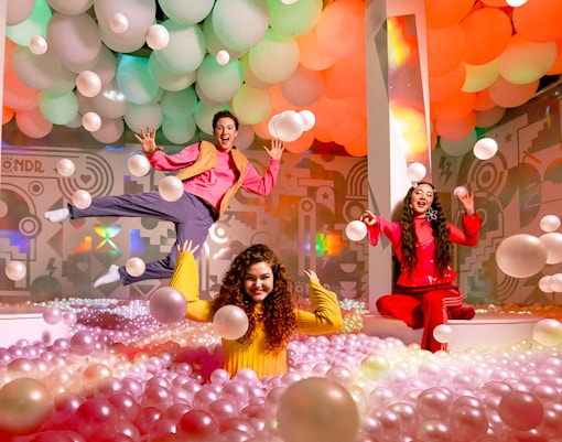 Visitors enjoying colorful ball pit at WONDR Experience.