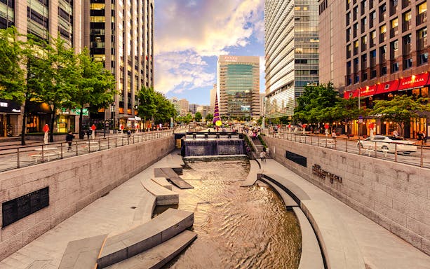 Cheonggyecheon Stream in Seoul with people walking along the promenade.