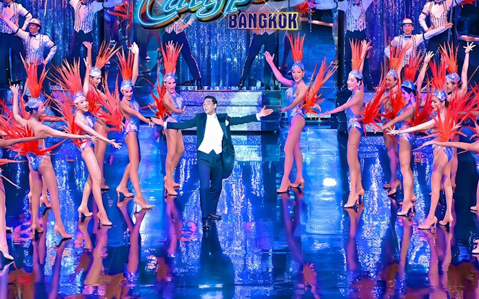 Calypso Cabaret performers in vibrant costumes on stage in Bangkok.