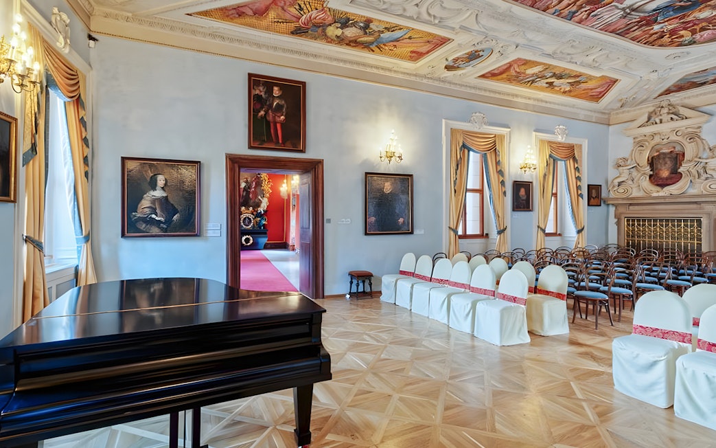 Lobkowicz Palace concert room with grand piano and arranged seating.