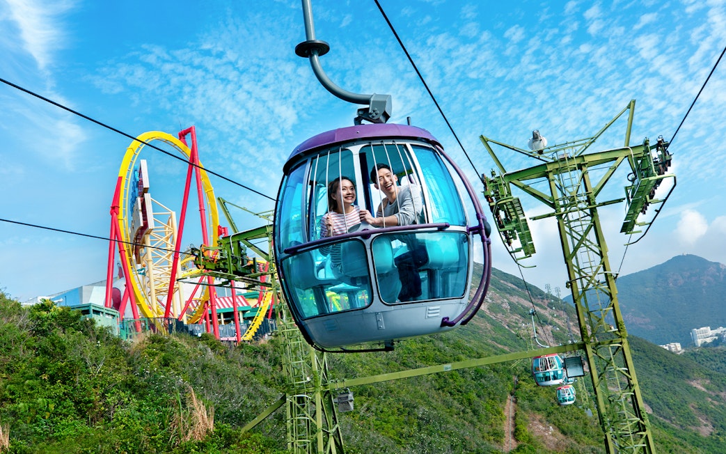 Cable car ride at Ocean Park Theme Park with roller coaster in the background.