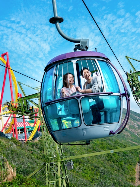 Cable car ride at Ocean Park Theme Park with roller coaster in the background.