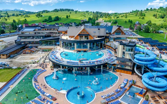 Zakopane hot springs complex with pools and water slides, view from Krakow day trip.