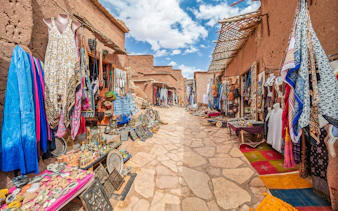 Traditional market stalls with textiles and crafts in Kasbah Ait Ben Haddou, Morocco.