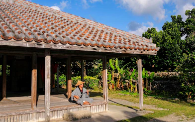 Man playing traditional instrument at Ishigaki Yaima Village, Okinawa, Japan.
