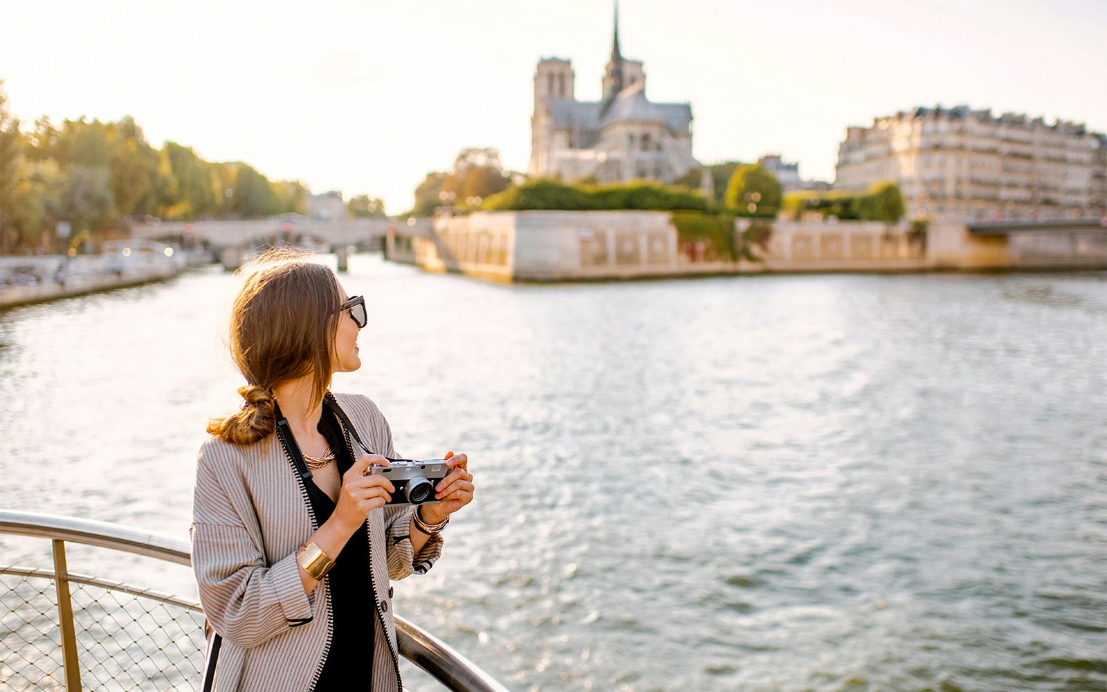 Seine River cruise boat passing by the Eiffel Tower in Paris, France.