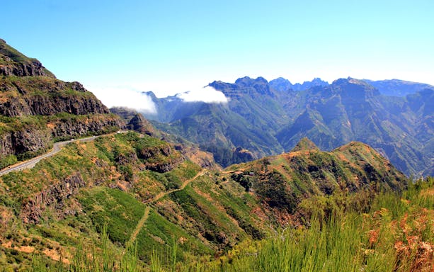 Mountainous landscape of Madeira with winding road and lush greenery.