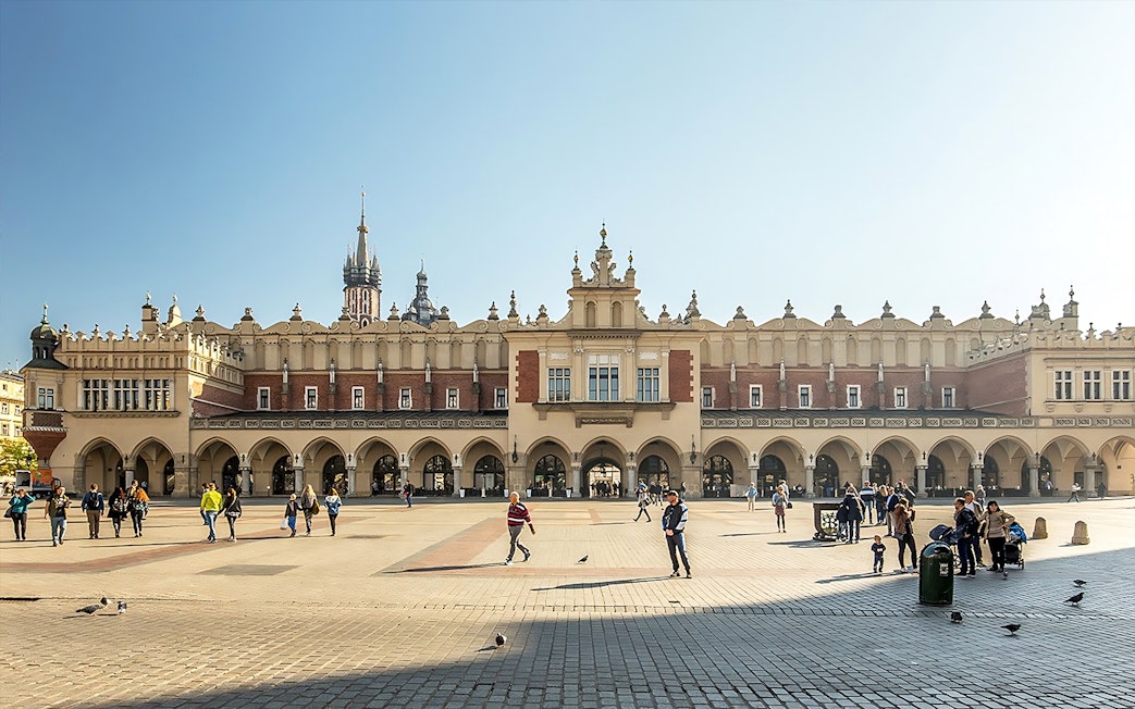 MNK Sukiennice exterior with people walking in Kraków's main square.