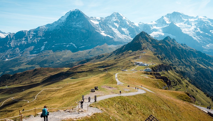 Hikers on Eiger Trail with view of Eiger Glacier near Alpiglen, Switzerland.