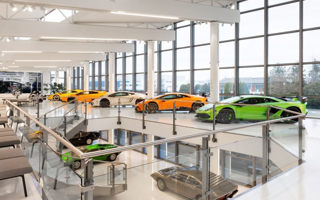 Lamborghini supercars display, featuring Miura and Countach models in a modern showroom.
