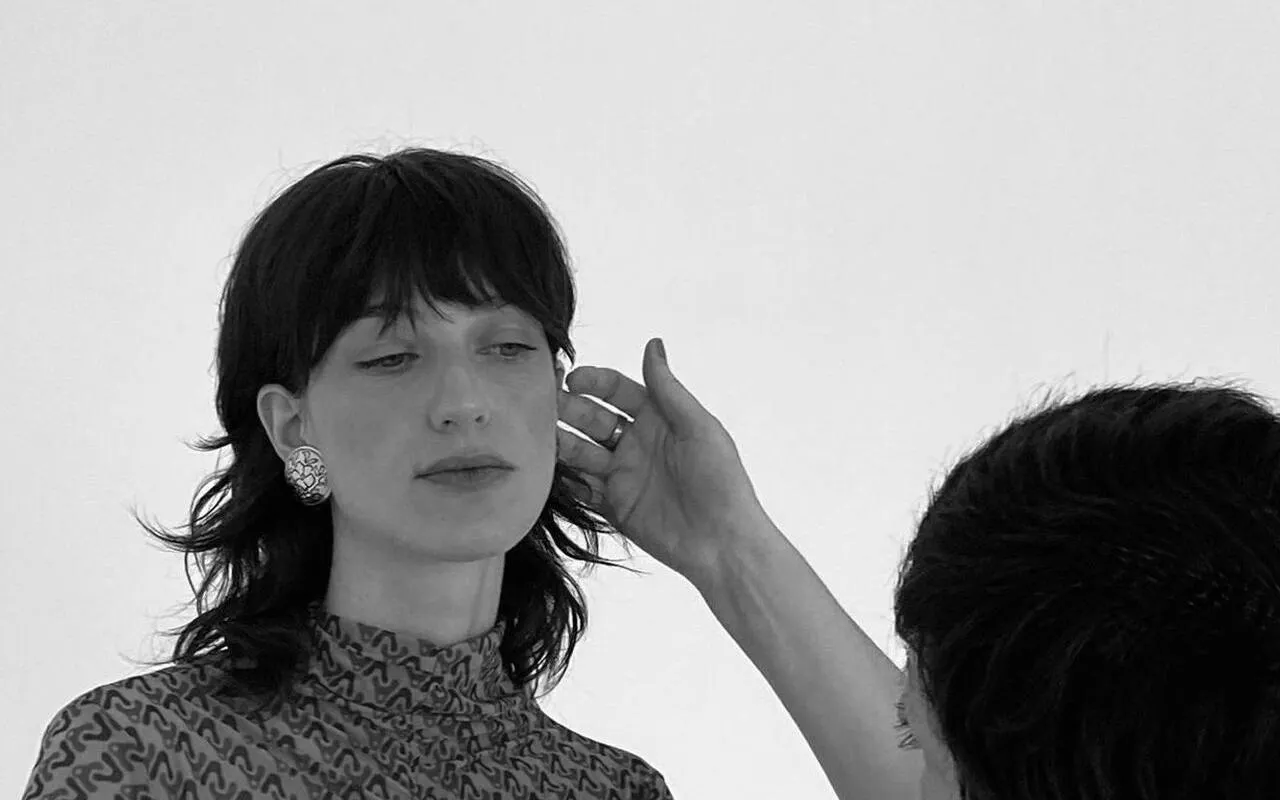 Stylist adjusting earrings during Barcelona fashion tour.