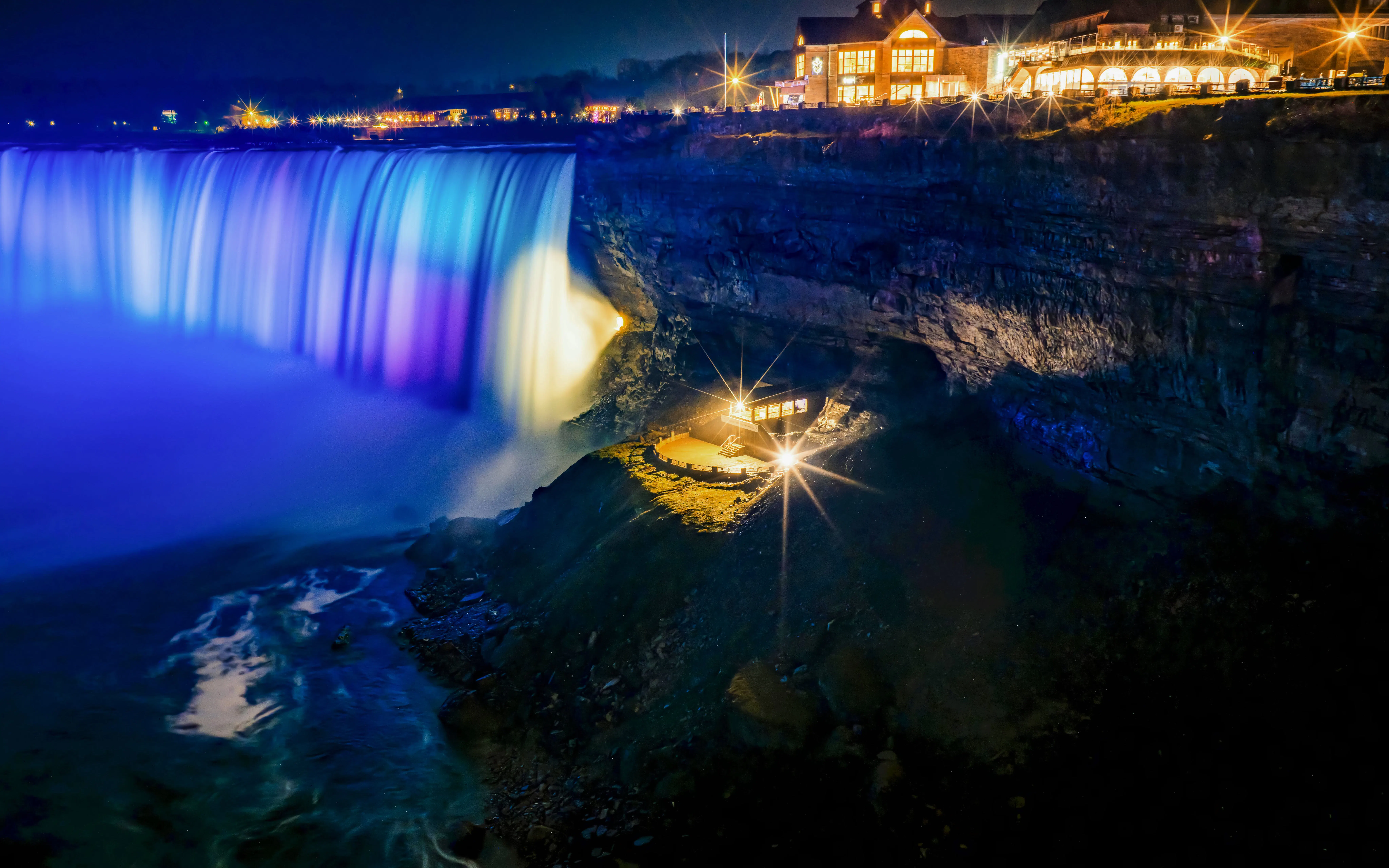 Journey Behind the Falls at night with illuminated waterfall and observation deck.