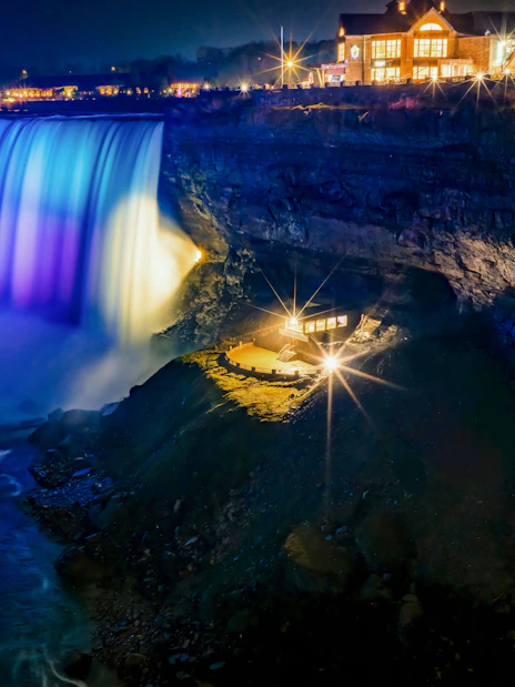 Journey Behind the Falls at night with illuminated waterfall and observation deck.