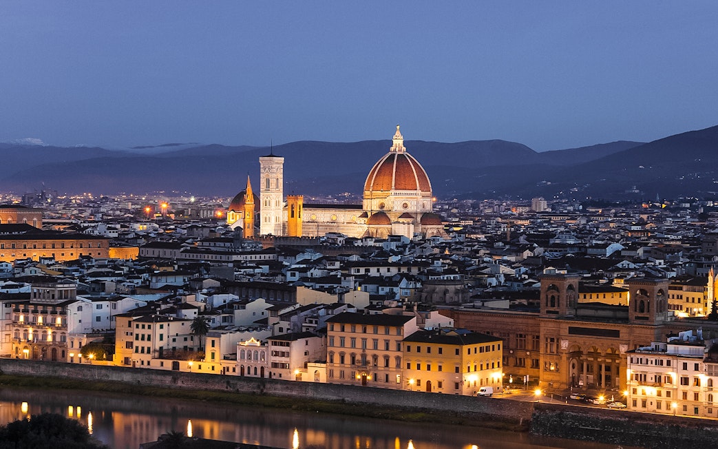 Florence cityscape at night from Piazzale Michelangelo, featuring the illuminated Duomo.