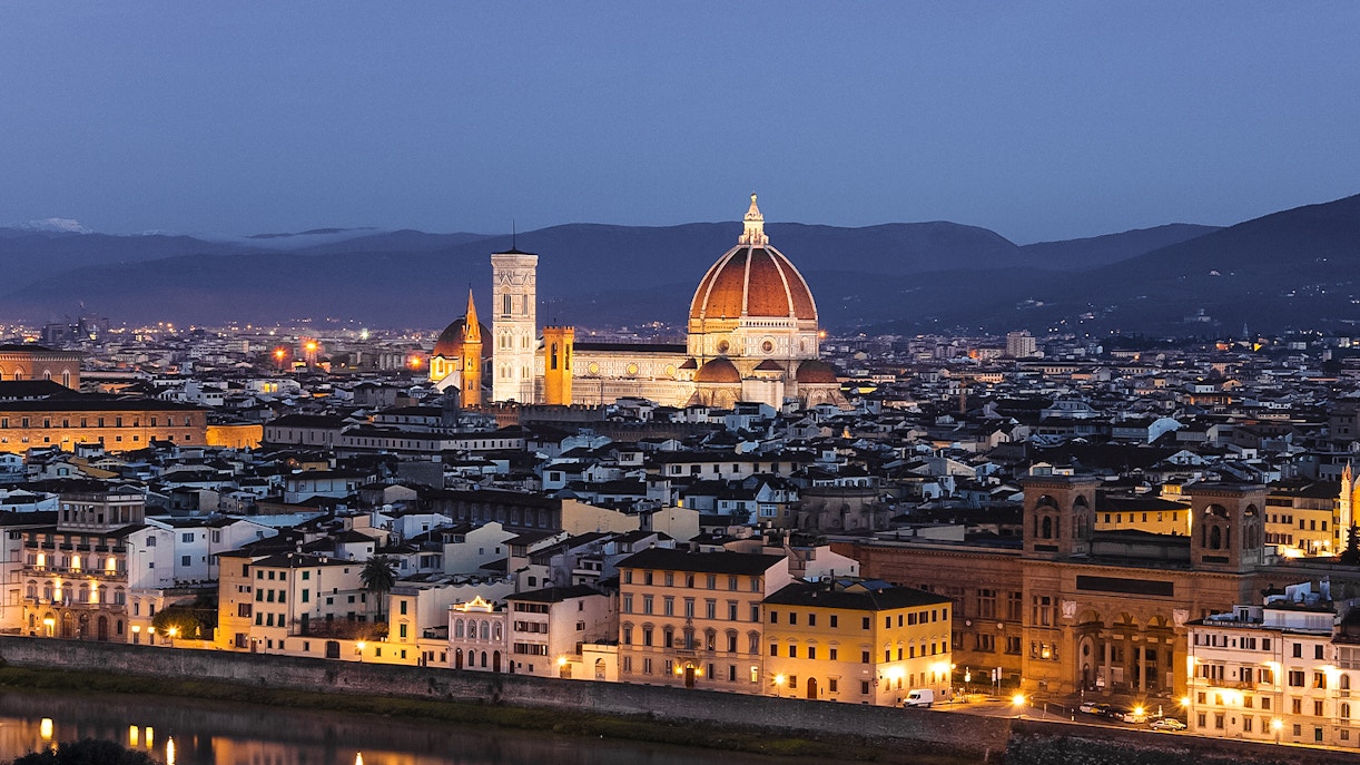 Florence cityscape at night from Piazzale Michelangelo, featuring the illuminated Duomo.