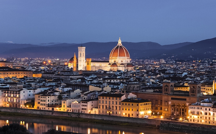 Florence cityscape at night from Piazzale Michelangelo, featuring the illuminated Duomo.