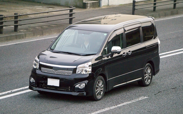 Minivan driving on a city road.