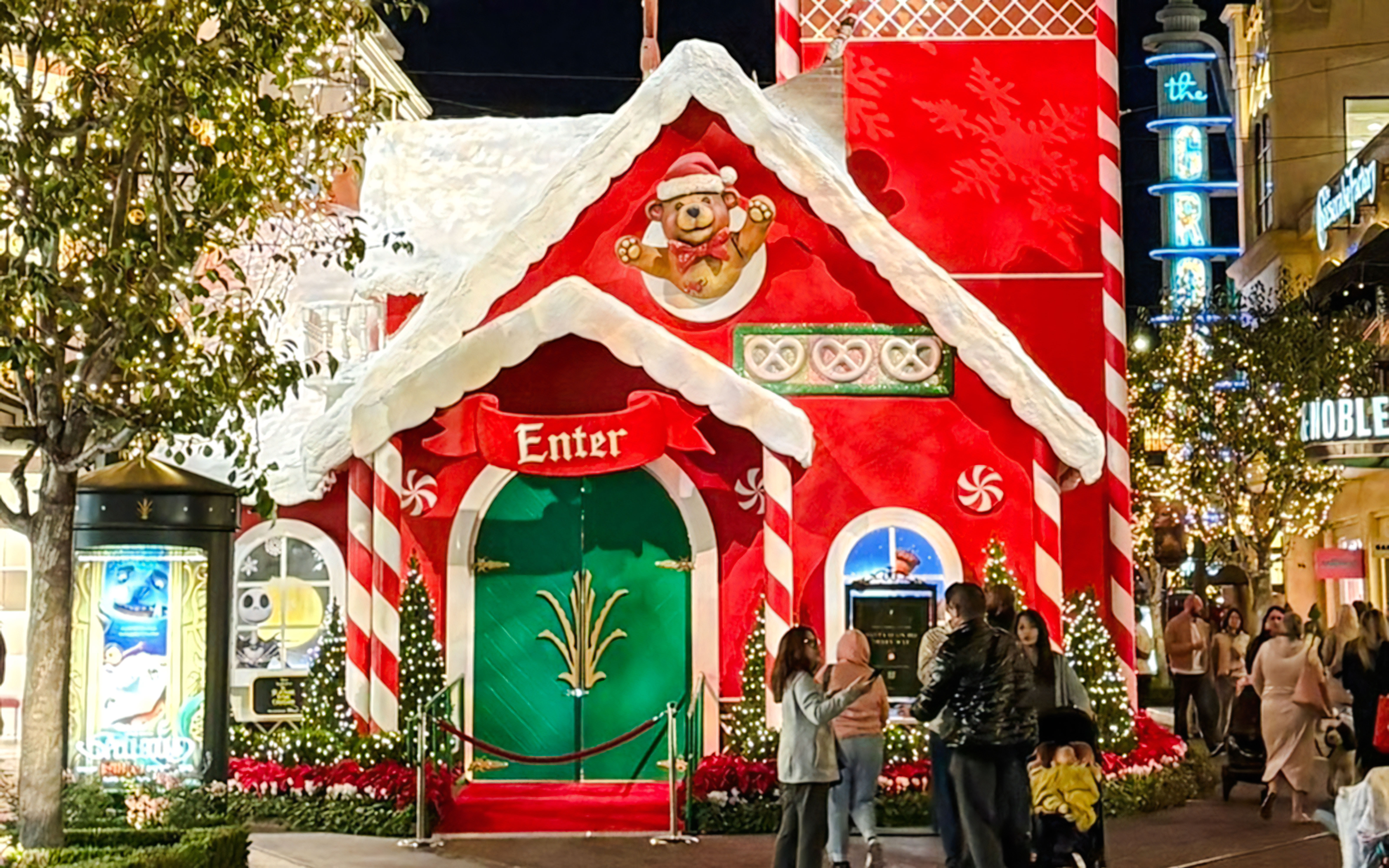 Festive Christmas house decoration at the Grove with people gathered around.