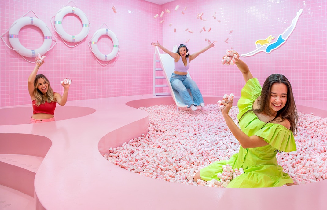 Visitors enjoying a pink marshmallow pool at a Liverpool attraction.
