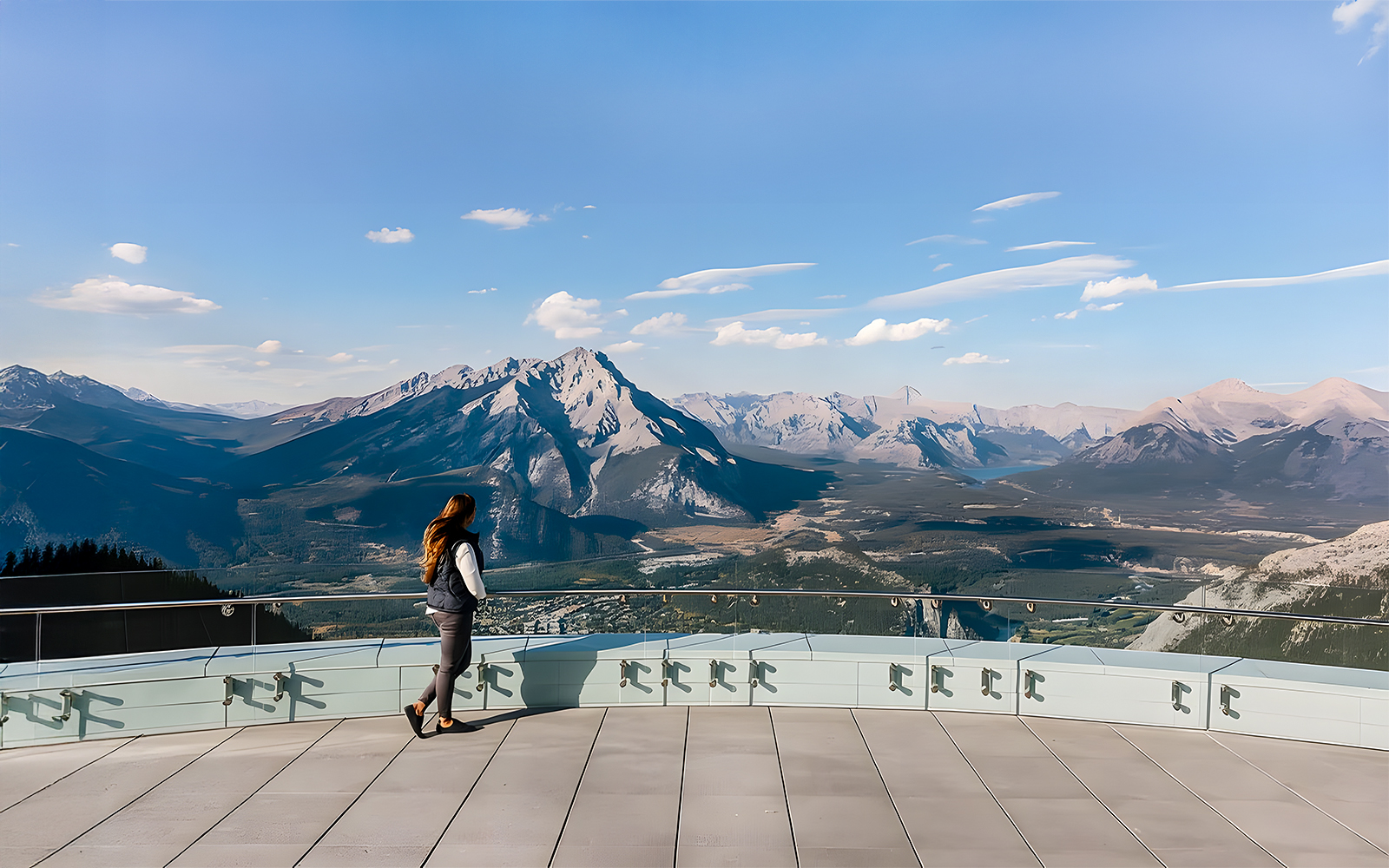 Person admiring the view of Sulphur Mountain from a scenic lookout in Banff, Canada.