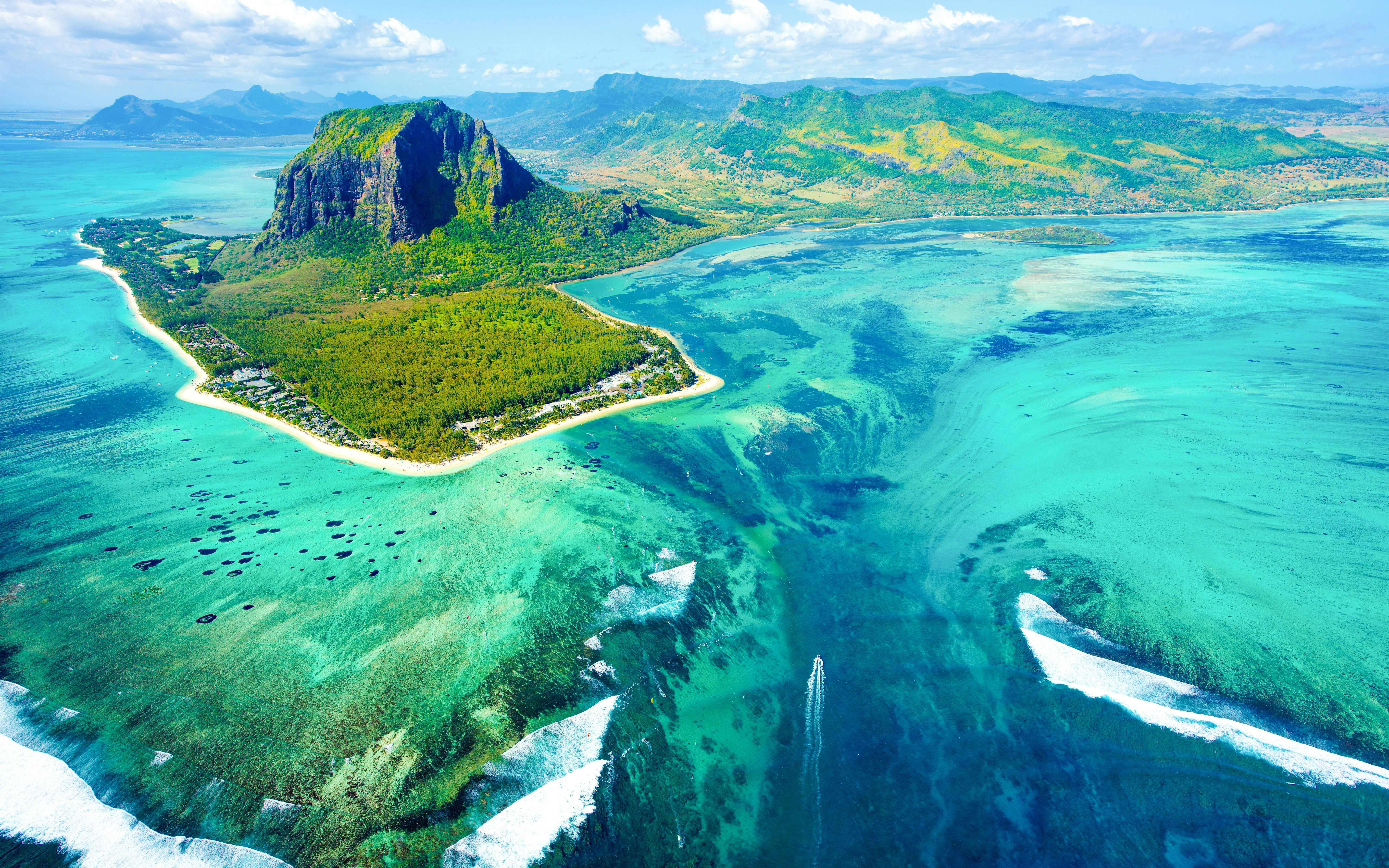 Underwater waterfall illusion off the coast of Mauritius with Le Morne Brabant in the background.