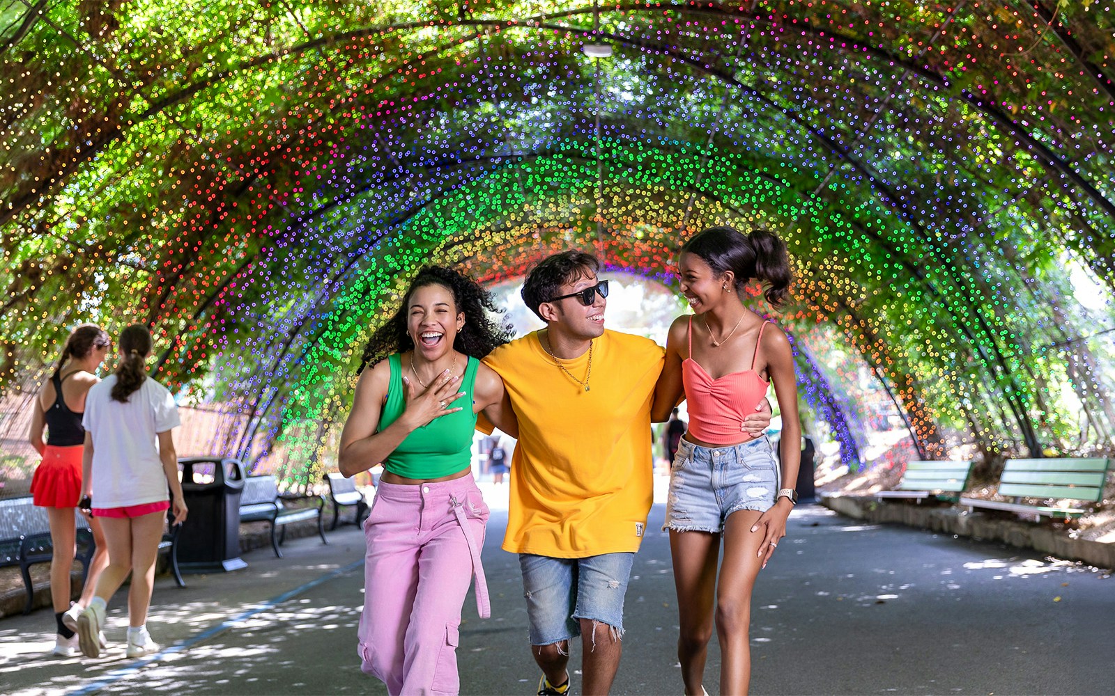 People enjoying a colorful light tunnel at Six Flags Over Georgia Arbor.