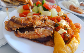 Traditional Dominican dish with eggplant, vegetables, and plantains on a plate during Santo Domingo food tour.