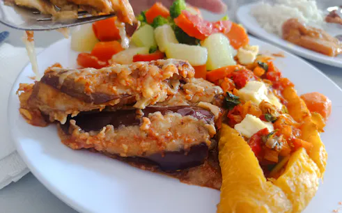 Traditional Dominican dish with eggplant, vegetables, and plantains on a plate during Santo Domingo food tour.