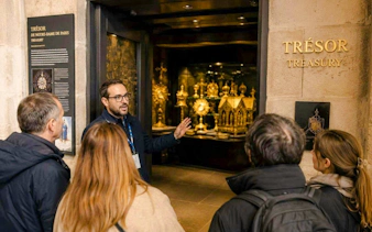Guide explaining artifacts in Notre-Dame treasury tour, Paris.