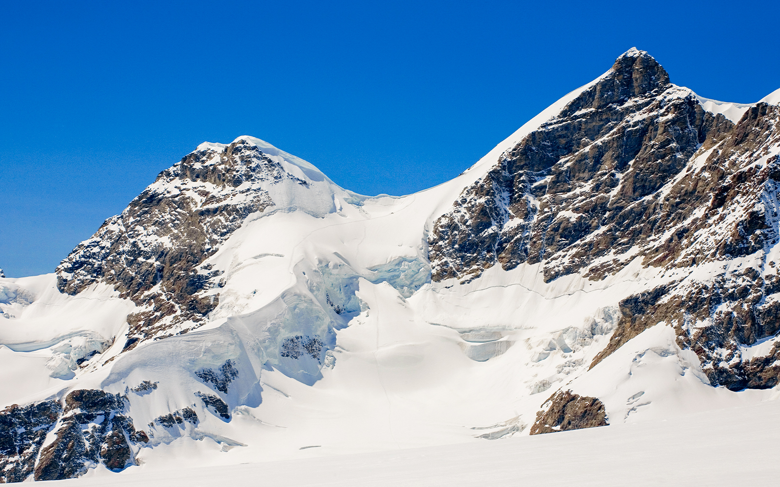 Hikers on Rottalsattel route with view of Jungfrau peak in Swiss Alps.