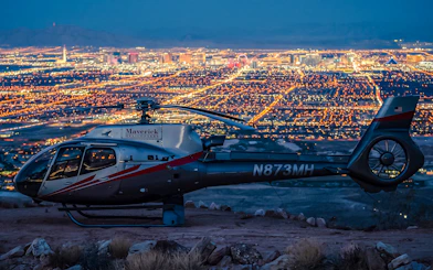 Helicopter on Red Rock Canyon with Las Vegas city lights in the background.