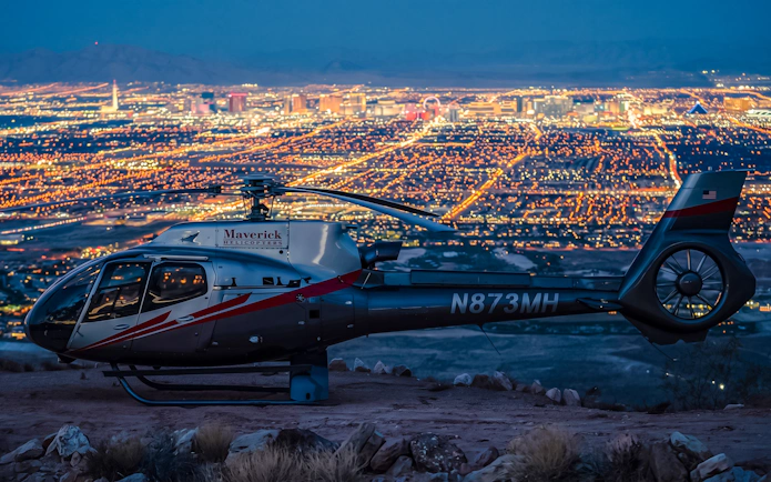 Helicopter on Red Rock Canyon with Las Vegas city lights in the background.