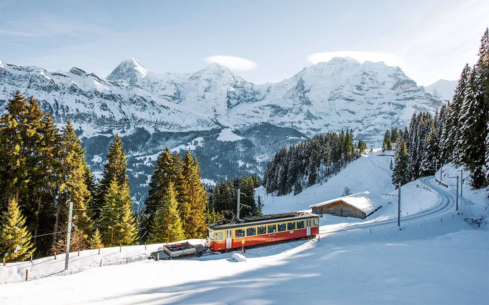 Lauterbrunnen-Mürren cableway train in snowy Swiss Alps landscape.