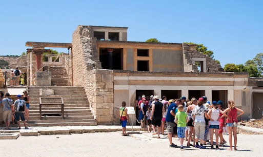 Knossos Palace ruins with ancient stone structures and columns, Crete, Greece.