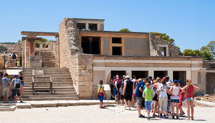 Knossos Palace ruins with ancient stone structures and columns, Crete, Greece.