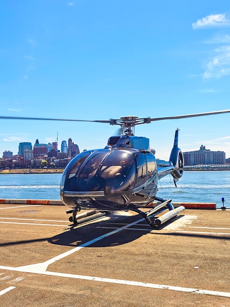 Helicopter on a helipad with New York City skyline in the background.
