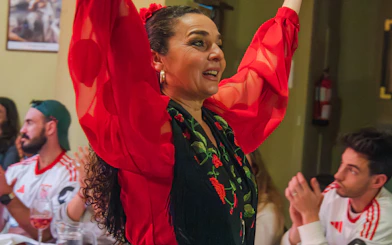 Flamenco dancer performing at Tablao La Cantaora, Seville, with audience clapping.