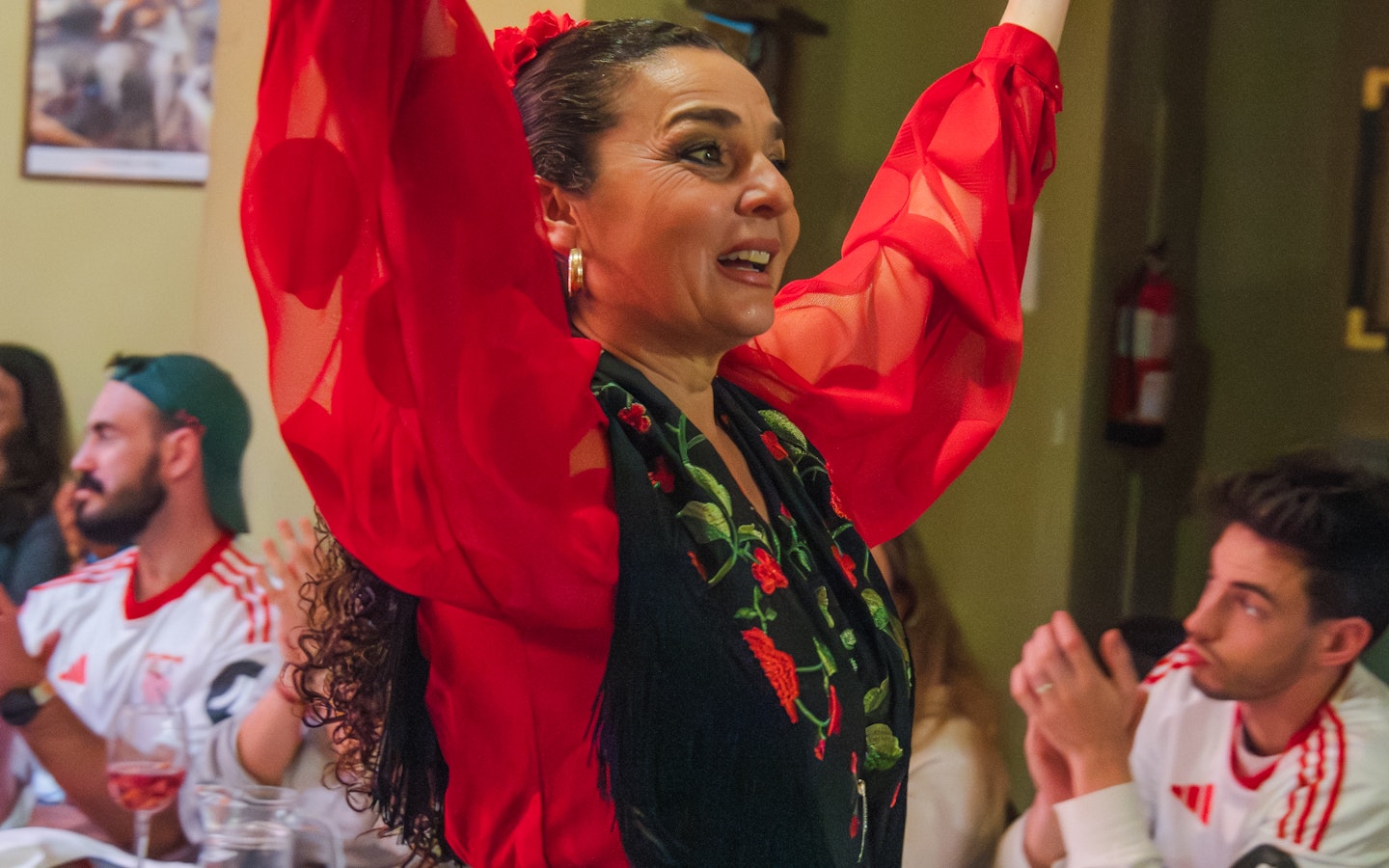 Flamenco dancer performing at Tablao La Cantaora, Seville, with audience clapping.